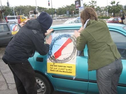 Demonstrators stick the protest poster to their car