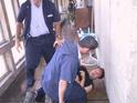 Yuval is thrown to the ground, the guards kneel on him