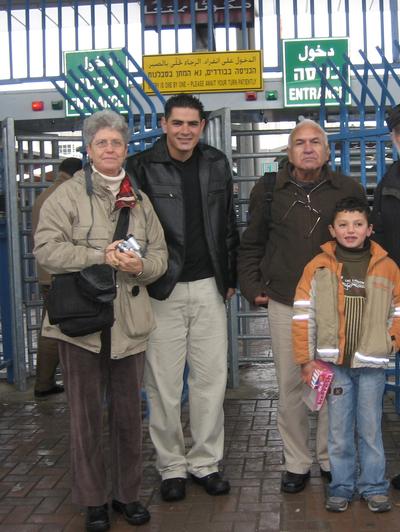 Kalandia checkpoint: conference organizer Hannah Knaz, Spanish representative Luca and Yaacov Manor with local boy