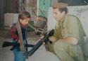 A soldier playing with a Palestinian child